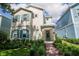 Charming two-story home with teal shutters, landscaped yard, and a welcoming brick pathway to the front door at 1430 Reunion Blvd, Reunion, FL 34747