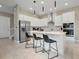 Modern kitchen with stainless steel appliances, island with bar seating, and sleek pendant lighting at 1430 Reunion Blvd, Reunion, FL 34747