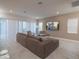 Open-concept living room featuring a plush sectional sofa, large windows, and a wall-mounted television at 1430 Reunion Blvd, Reunion, FL 34747