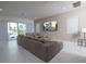 Spacious living room with a sectional sofa, large TV, and sliding glass doors to the outdoor pool area at 1430 Reunion Blvd, Reunion, FL 34747