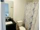 Well-lit bathroom with modern vanity, toilet, and a marble patterned shower curtain at 3428 Tranquil Trail, Kissimmee, FL 34747