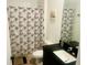 Bathroom featuring a shower/tub combination, dark vanity, and leaf-patterned shower curtain at 3428 Tranquil Trail, Kissimmee, FL 34747