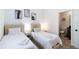 Bright bedroom featuring two twin beds, soft, neutral decor, and an ensuite bathroom at 3428 Tranquil Trail, Kissimmee, FL 34747