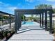 Community pool framed by dark pergola, offering a refreshing escape with clear water and serene surroundings at 3428 Tranquil Trail, Kissimmee, FL 34747