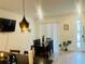 Bright dining room features a modern light fixture, a dark wood table with seating for six, and sliding glass doors to a patio at 3428 Tranquil Trail, Kissimmee, FL 34747
