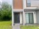 Modern home with sleek design, notable address, covered entrance, and lush front yard at 3428 Tranquil Trail, Kissimmee, FL 34747