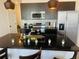 Kitchen island with dark granite, stainless steel appliances, and pendant lighting at 3428 Tranquil Trail, Kissimmee, FL 34747