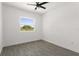Bright bedroom featuring gray tile floors, white walls, ceiling fan, and window at 4116 Winona Dr, Orlando, FL 32812