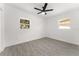 A light and airy bedroom features wood-look tile flooring and two windows at 4116 Winona Dr, Orlando, FL 32812