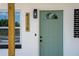Close up of the front door, with brick accents, house numbers and a front porch with wooden columns at 4116 Winona Dr, Orlando, FL 32812