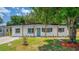 Charming single-story home featuring a well-maintained lawn, a vibrant teal door, and a covered front porch with wood pillars at 4116 Winona Dr, Orlando, FL 32812