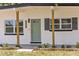 Charming exterior featuring a welcoming sage green front door, brick accents, and a well-manicured lawn with brick borders at 4116 Winona Dr, Orlando, FL 32812