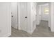 Hallway with gray wood-like tile and white doors at 4116 Winona Dr, Orlando, FL 32812