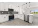 Modern kitchen featuring white cabinetry, stainless steel appliances, and wood-look tile flooring at 4116 Winona Dr, Orlando, FL 32812