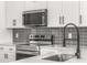 Close up of a modern kitchen with stainless steel appliances and a stylish backsplash at 4116 Winona Dr, Orlando, FL 32812