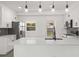 Bright, modern kitchen with white cabinets, stainless steel appliances, pendant lighting, and a breakfast bar with quartz countertops at 4116 Winona Dr, Orlando, FL 32812