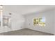 Bright living space with light gray flooring and white walls featuring a large window and view of the front door at 4116 Winona Dr, Orlando, FL 32812