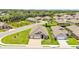 Aerial view of a home nestled in a quiet neighborhood with lush greenery and a pond at 7890 Lake James Blvd, Lakeland, FL 33810