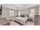 Bedroom featuring chandelier, wood floors, accent pillows, and plantation shutters at 7890 Lake James Blvd, Lakeland, FL 33810