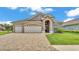 Charming single-story home featuring a three-car garage, manicured lawn, and stone accents at 7890 Lake James Blvd, Lakeland, FL 33810