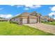 Beautiful home with a three-car garage and stone accents surrounded by a lush green lawn at 7890 Lake James Blvd, Lakeland, FL 33810