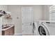 Bright laundry room features washer, dryer, cabinet and sink at 7890 Lake James Blvd, Lakeland, FL 33810