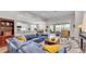 Bright living room featuring a plush blue sofa, hardwood floors, and sliding glass doors at 7890 Lake James Blvd, Lakeland, FL 33810