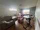 Neutral living room with leather sofa, patterned armchair, and multiple windows at 801 Quintilian Ave, Orlando, FL 32809