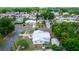 This is an aerial view of the house with a light colored roof, surrounded by lush green trees in a neighborhood at 1161 Orangewood Ave, Deland, FL 32724