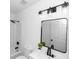 Bright bathroom with modern black fixtures, white vanity, framed mirror, and a shower-tub combination at 1161 Orangewood Ave, Deland, FL 32724