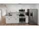This is a bright kitchen with stainless steel appliances, white shaker cabinets, and quartz countertops at 1161 Orangewood Ave, Deland, FL 32724
