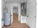 Utility room with water heater and furnace, featuring durable wood-look flooring at 1161 Orangewood Ave, Deland, FL 32724