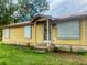 Charming single-story home with a covered front porch and metal awnings on the windows at 2220 Woods Trl, Lakeland, FL 33809