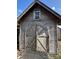 Weathered outbuilding with arched doors and a window, adding character to the property at 2220 Woods Trl, Lakeland, FL 33809