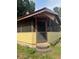 Front entrance porch with yellow siding and screened windows and door at 2220 Woods Trl, Lakeland, FL 33809