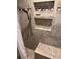Bathroom shower features a built in bench and shower head with stone tile walls and shelf at 2220 Woods Trl, Lakeland, FL 33809