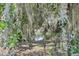 Scenic backyard featuring lush trees with flowing Spanish moss and glimpses of a serene pond view at 229 St Thomas Dr, Mulberry, FL 33860