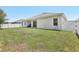 Expansive backyard with a covered patio and white fence, perfect for outdoor activities at 229 St Thomas Dr, Mulberry, FL 33860