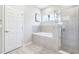Bathroom featuring a tiled tub, walk-in glass shower, and serene natural light at 229 St Thomas Dr, Mulberry, FL 33860