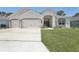 Charming single-story home featuring a three-car garage, well-manicured lawn, and beautiful front entrance at 229 St Thomas Dr, Mulberry, FL 33860