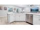 Kitchen island featuring stainless steel dishwasher and double sink overlooking the living area at 229 St Thomas Dr, Mulberry, FL 33860