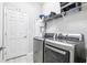 Functional laundry room with modern washer and dryer and ample storage shelves at 229 St Thomas Dr, Mulberry, FL 33860