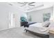 Main bedroom with carpet flooring, ceiling fan, large windows, and access to ensuite bathroom at 229 St Thomas Dr, Mulberry, FL 33860