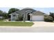 Charming single-story home with well-manicured lawn, gray exterior, and attached two-car garage at 938 Oxford Way, Lake Wales, FL 33853