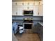 Spacious kitchen features stainless steel appliances, stylish gray cabinets, and granite countertops at 938 Oxford Way, Lake Wales, FL 33853