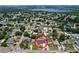 Aerial view showcasing a home with a screened pool in a residential neighborhood and a lake in the background at 212 Overlook Dr, Winter Haven, FL 33884