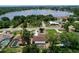 Aerial view of a home with a screened pool and a lake view, surrounded by mature trees and lush landscaping at 212 Overlook Dr, Winter Haven, FL 33884