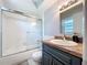 A bathroom with white tub, glass shower doors, toilet and dark blue vanity at 212 Overlook Dr, Winter Haven, FL 33884