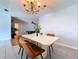 Dining room with light gray walls, tile floors, chandelier, modern table set and view to game room at 212 Overlook Dr, Winter Haven, FL 33884