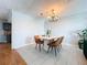 Dining room with light gray walls, tile floors, chandelier, modern table set and view to kitchen at 212 Overlook Dr, Winter Haven, FL 33884